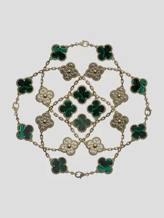 Overhead shot of interlocking gold Van Cleef & Arpels Alhambra bracelets featuring malachite and diamond clover motifs on a grey backdrop.