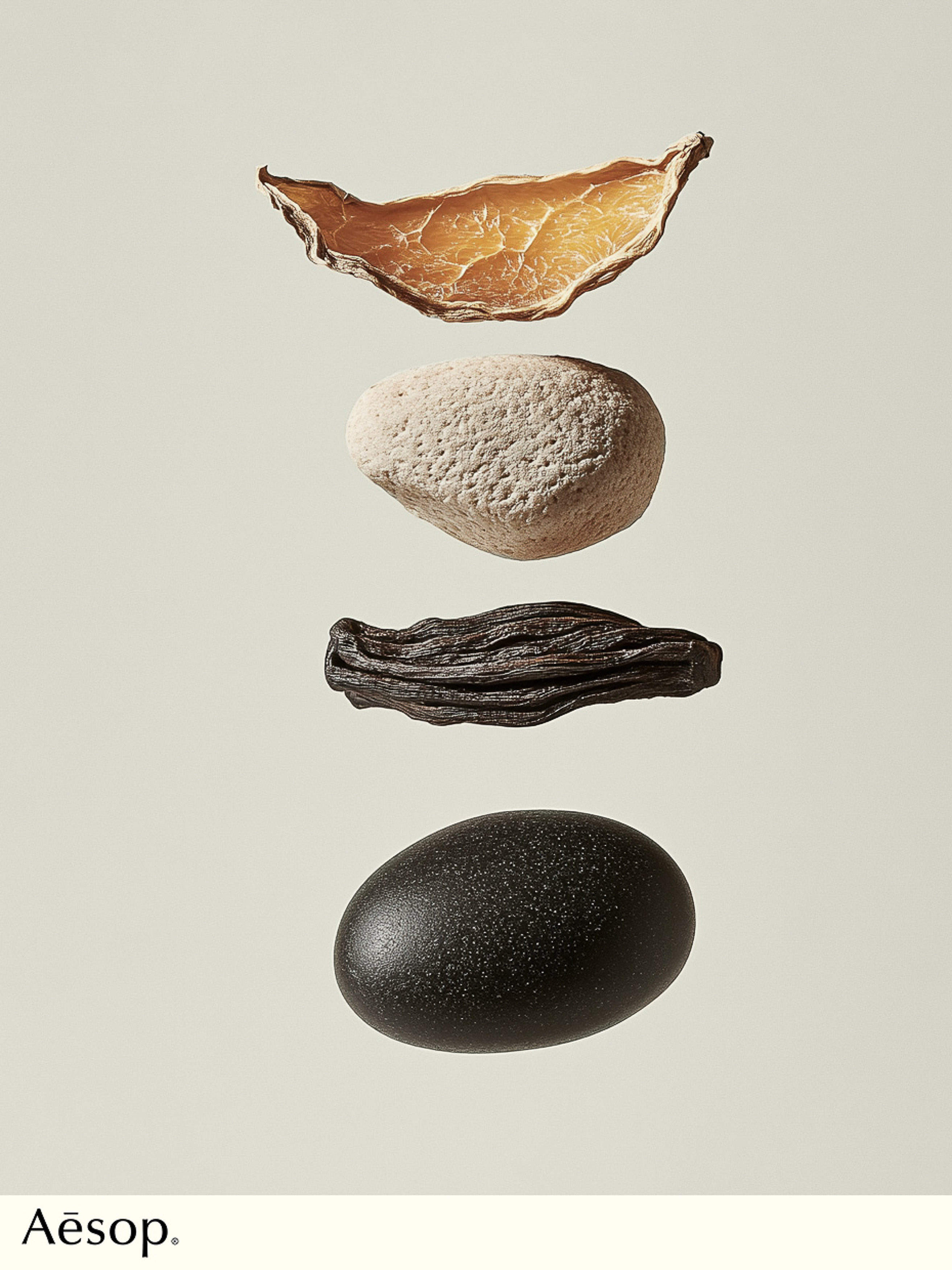 Still life of amber resin, stone, black wood, and a dark stone with the Aesop logo in the lower left corner on a pale background.
