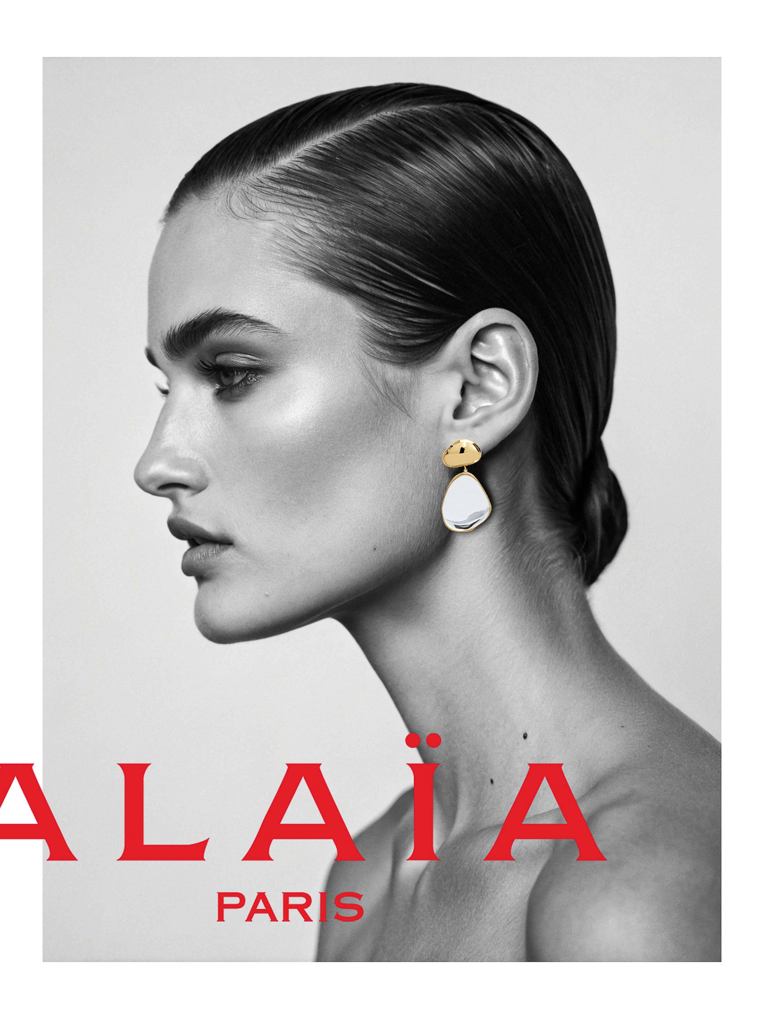 Black and white fashion portrait of an adult woman in profile wearing statement earrings with visible Alala Paris text.