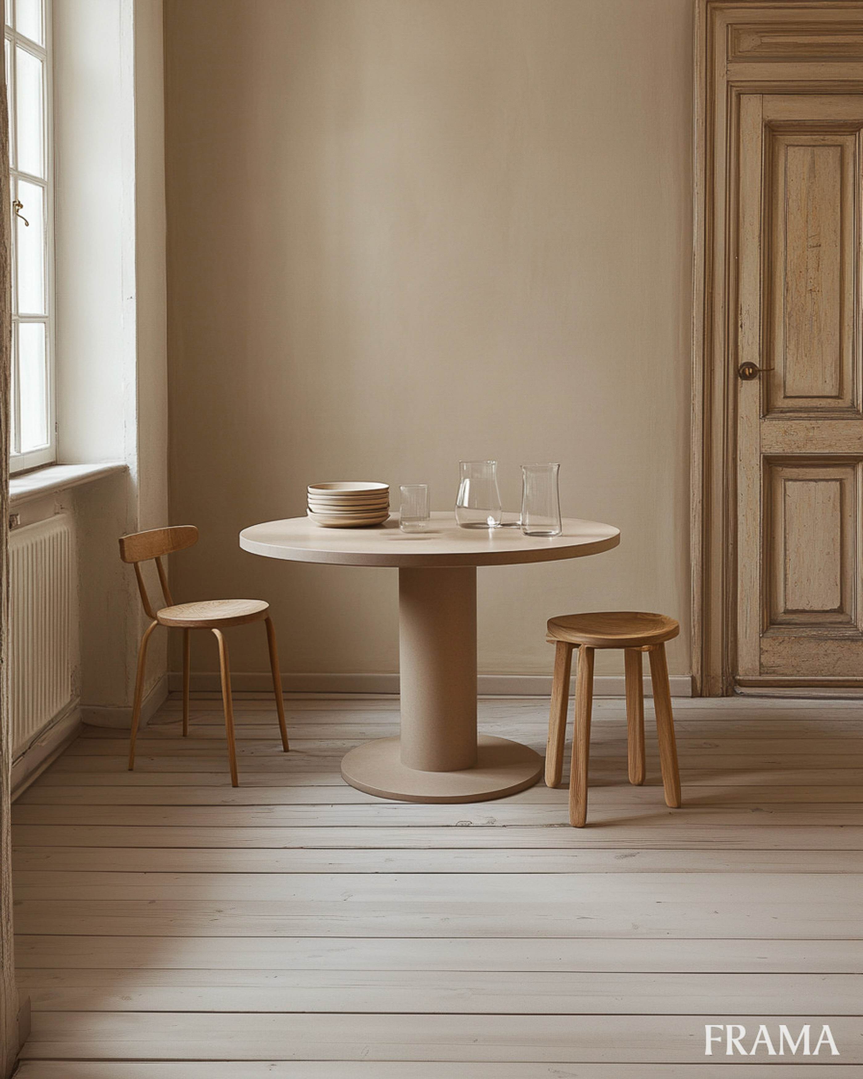 Interior with round table, chairs, stool, and tableware. Light beige walls, wooden floors, and natural light fill the cozy space.