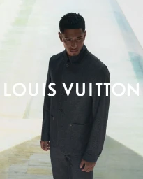 Jude Bellingham wearing a dark grey jacket for Louis Vuitton Men's Formalwear 2026 Campaign against a minimalist architectural background.
