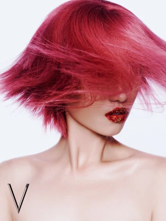 Glamour shot featuring an adult woman with pink hair and glittery red lips against a white background, highlighting hair and makeup artistry.