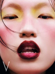 Close-up beauty portrait of a model with yellow eyeshadow, pink blush, and deep red lipstick for V Magazine China.