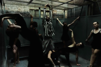 Group of dancers in an enclosed metallic structure posing in various dramatic postures photographed by Myrthe Giesbers.