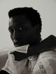 Close-up portrait of Calvin Royal III wearing a white patterned shirt against a plain light background.