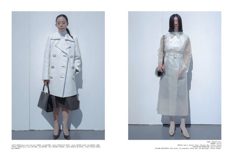 Two Asian women pose in light-colored, stylish coats against a plain white background, each holding a handbag and wearing heels.