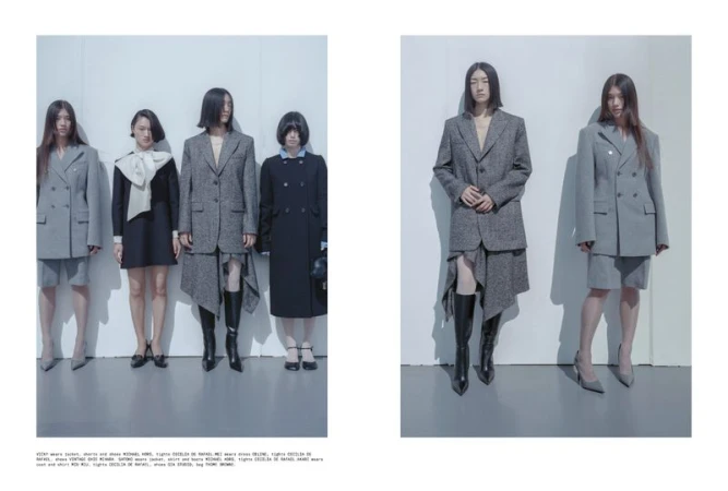 Fashion editorial shot of five women in diverse suit and dress styles, arranged against a minimalist white wall in a studio setting.