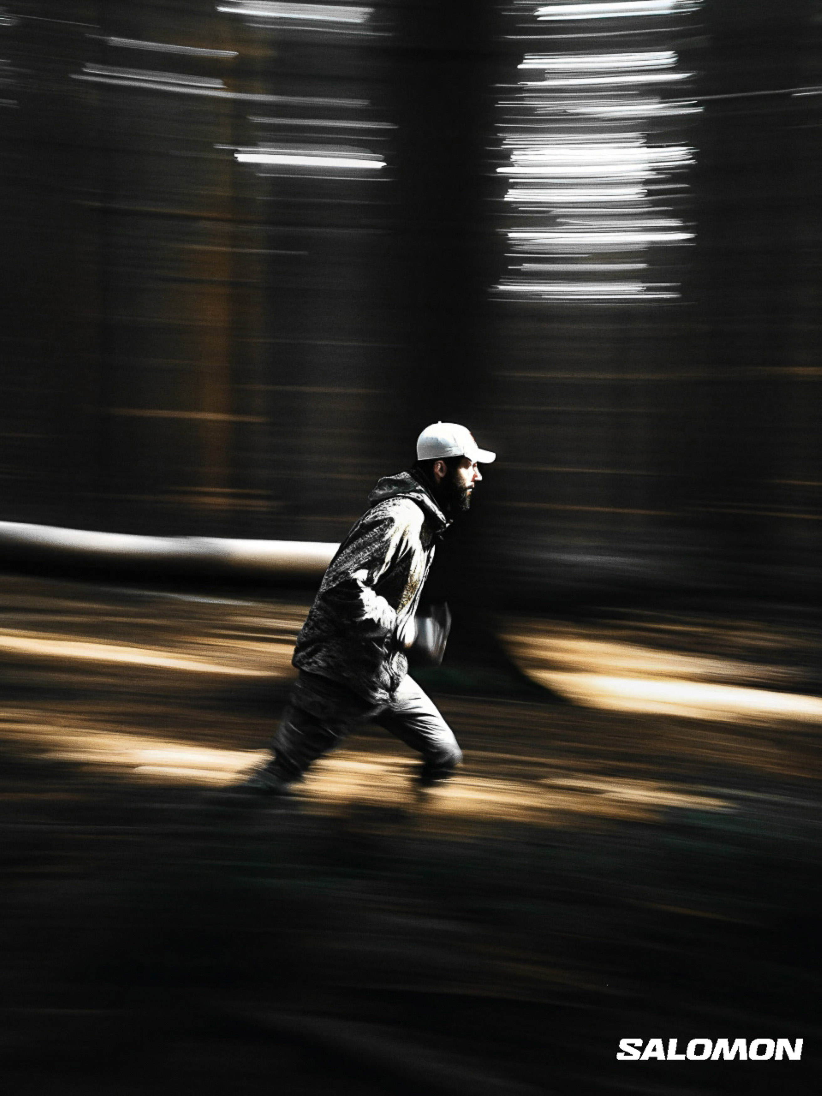 Adult male in sportswear runs through a forest with a motion blur effect, captured in a vertical, outdoor shot with diffused lighting.