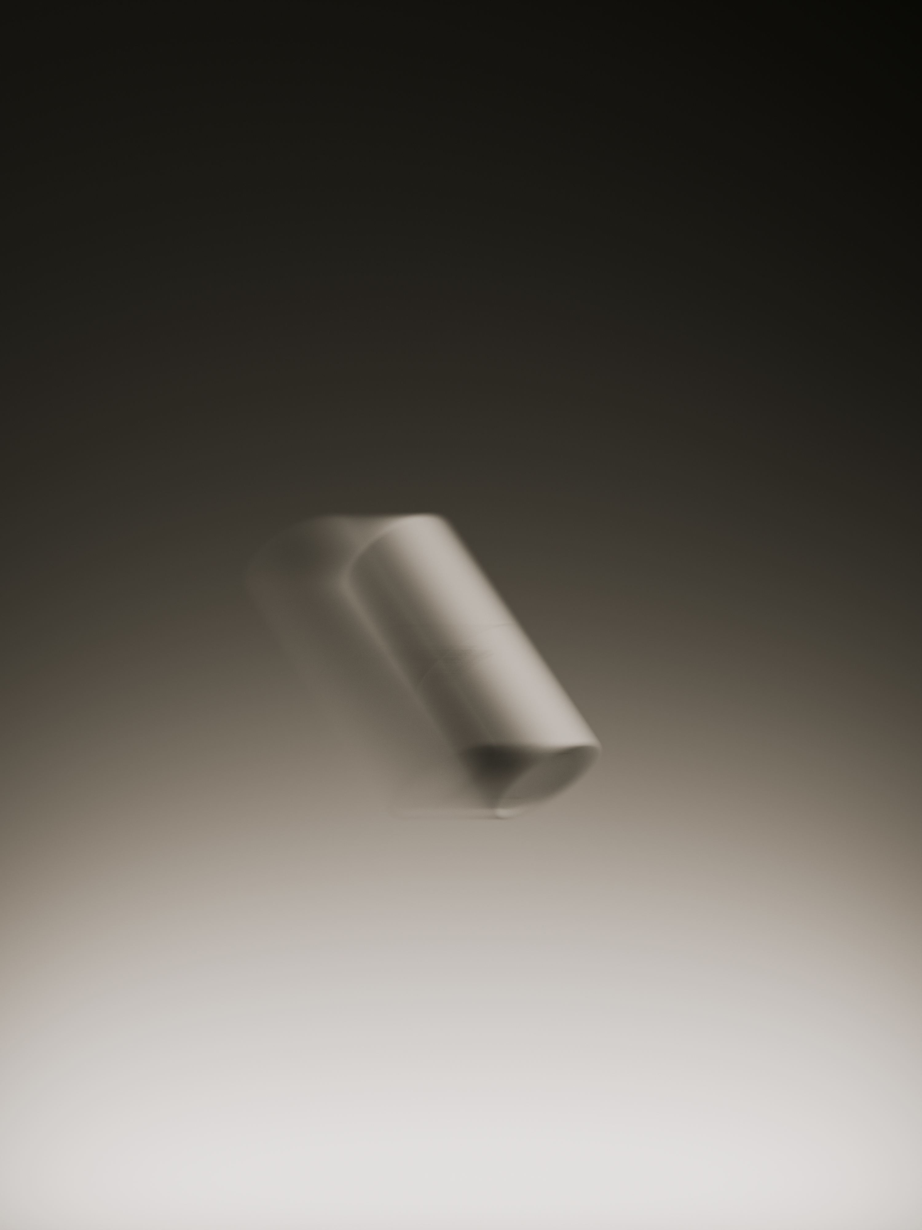 Abstract photography of a cylindrical object, possibly chalk, set against a gradient backdrop with motion blur, creating a minimalist composition.
