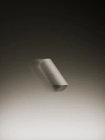 Abstract photography of a cylindrical object, possibly chalk, set against a gradient backdrop with motion blur, creating a minimalist composition.