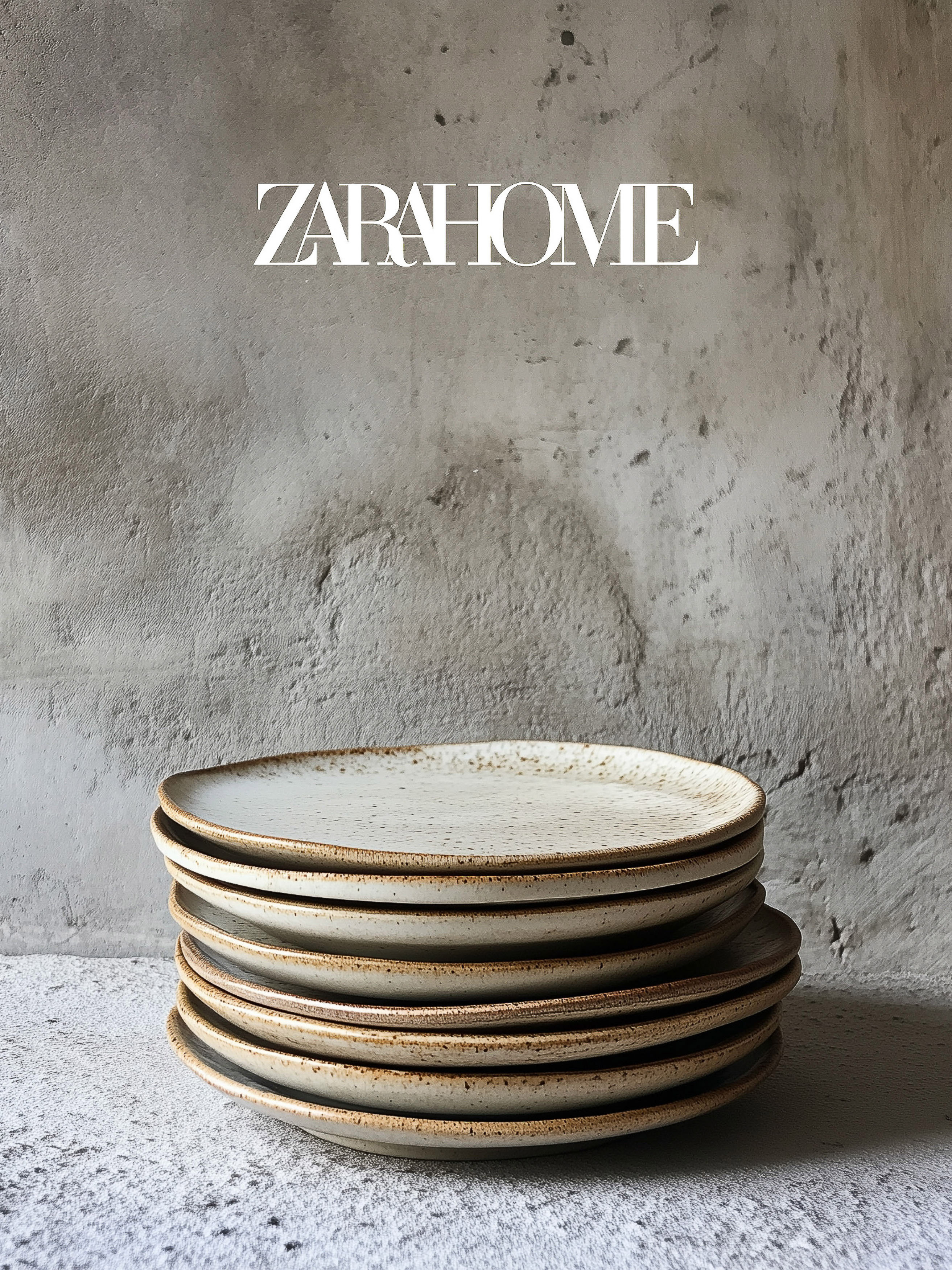 Stack of round speckled stoneware plates against textured grey wall, product shot for Zara Home, minimalist tableware.