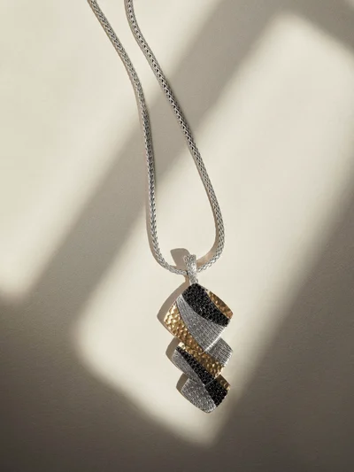John Hardy geometric pendant necklace with hammered gold, pavé crystals, and black stones on a silver woven chain.