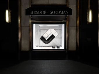 Saint Laurent window display at Bergdorf Goodman featuring a geometric sculpture and leather accessories.