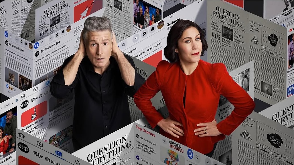 Two people pose against a backdrop of newspaper-themed graphics with headlines like 'Question Everything' and 'Top Stories'.