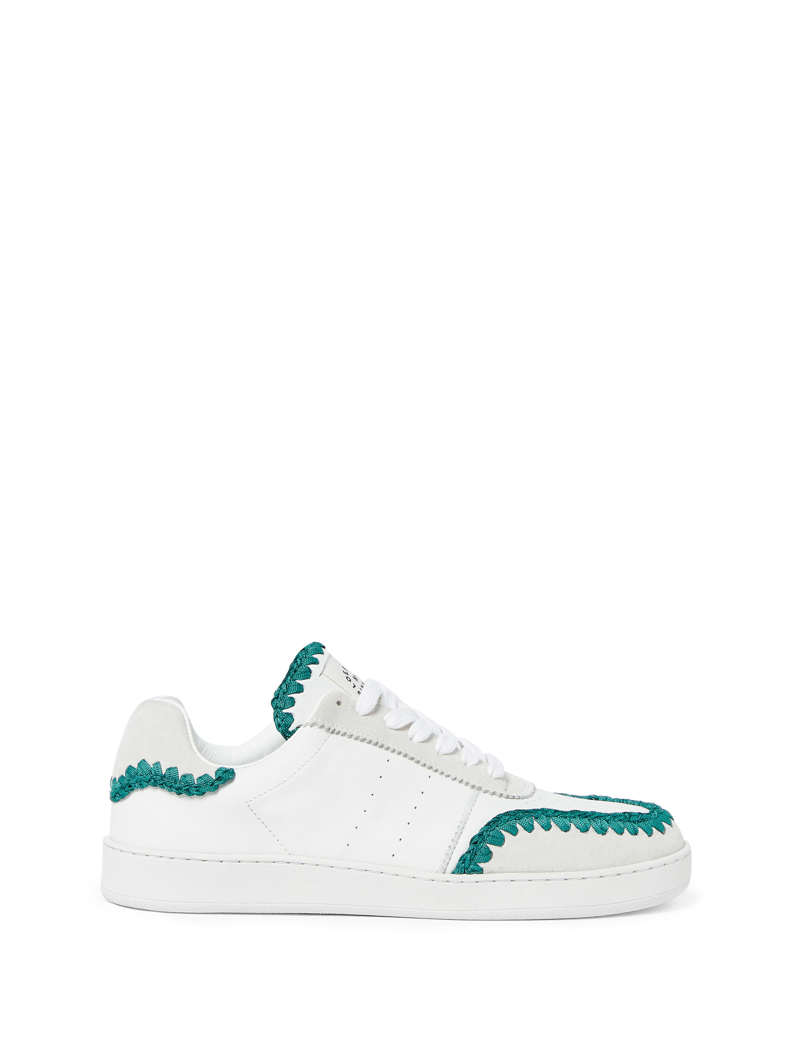 White sneaker with green crochet-like trim on a white background, studio shot, product photography for online fashion retail.