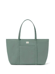 Loeffler Randall sage green canvas tote bag with front pocket centered on a solid white studio background.