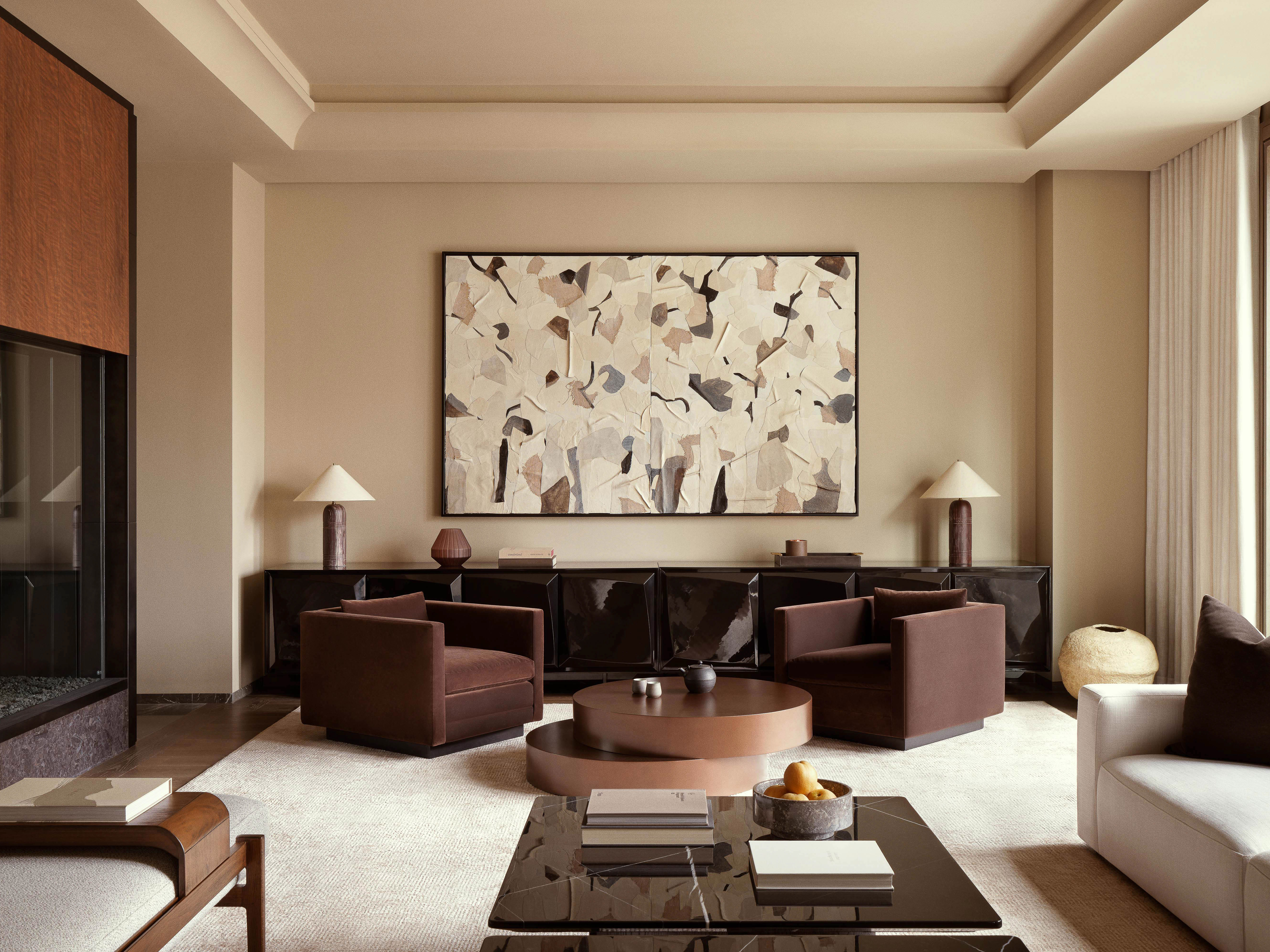 Living room interior showcases modern furniture, abstract art, and neutral tones, complemented by soft lighting and stylish decor elements.
