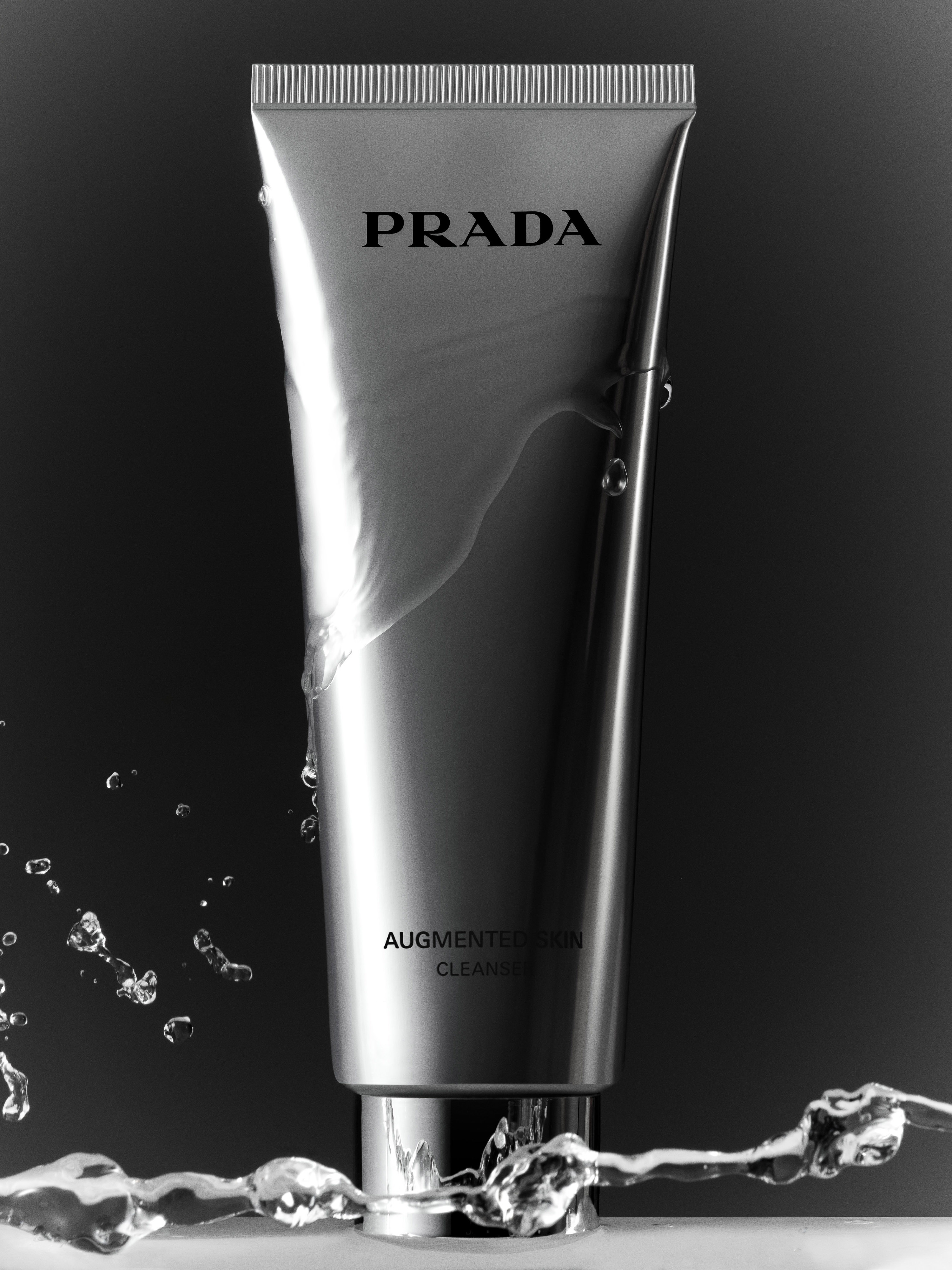 Prada skincare product in a silver tube with water droplets on a black backdrop for beauty, product, skincare advertising photography.