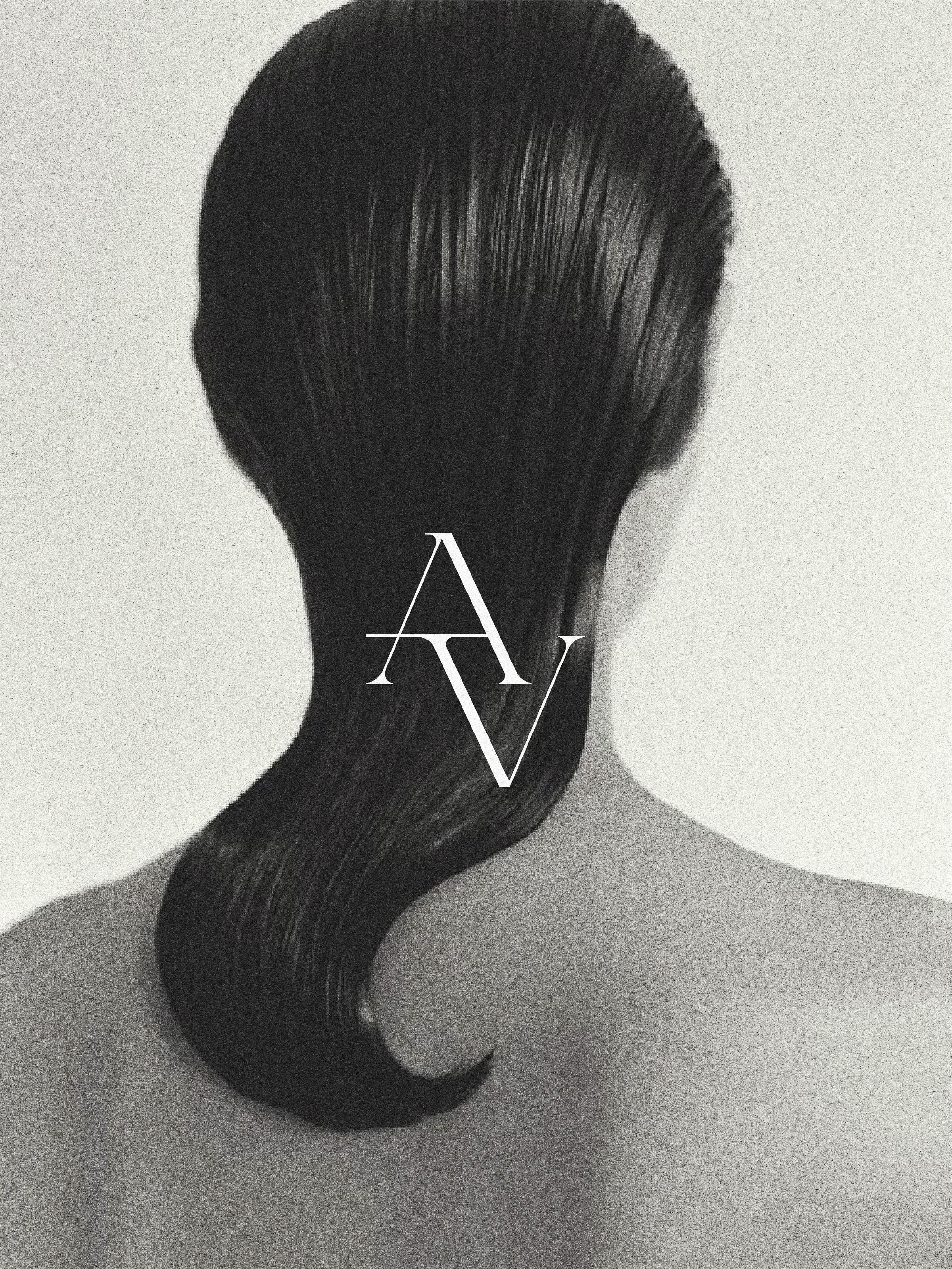 Black and white beauty shot of a woman from the back, featuring a sleek, wet hairstyle, and a blurred background, emphasizing minimalist aesthetic.