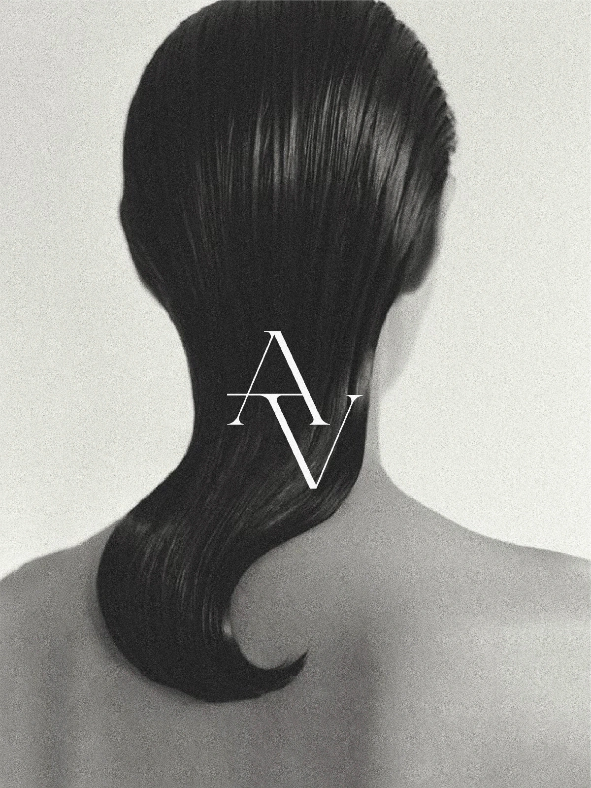 Back view of a person with slicked-back dark wet-look hair and bare shoulders against a light background with an AV monogram.