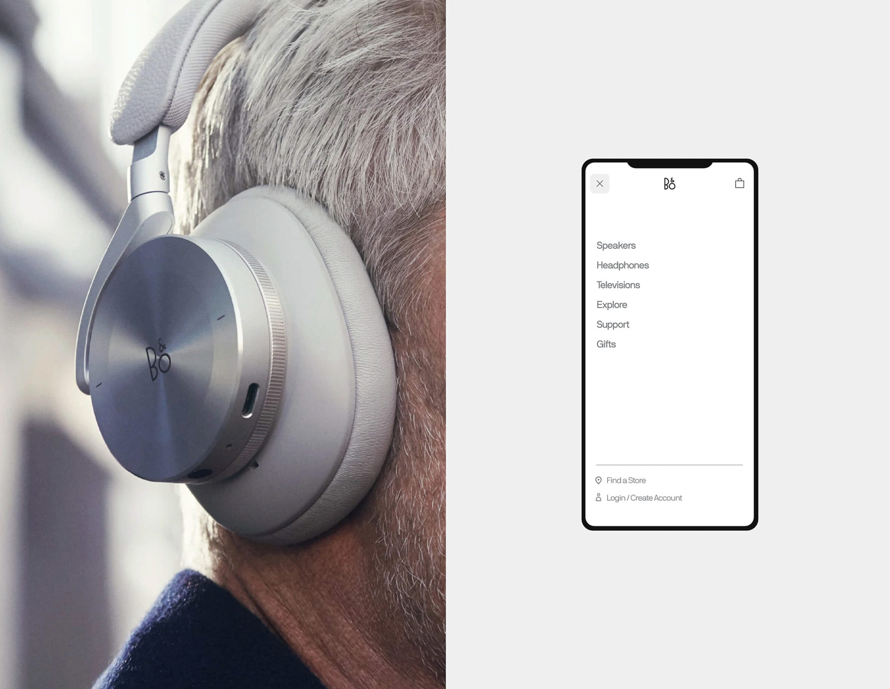 Close-up of silver Bang & Olufsen headphones worn by a person with gray hair; out-of-focus mobile phone displays B&O interface.