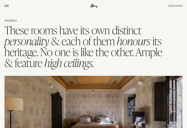 Interior of a bedroom with textured walls, decorative ceiling, large bed, and lamp, with an open door to an adjacent room.