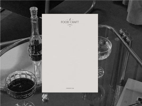 Crystal decanter and glassware are arranged on a reflective service table with a white paper advertisement for a food product.