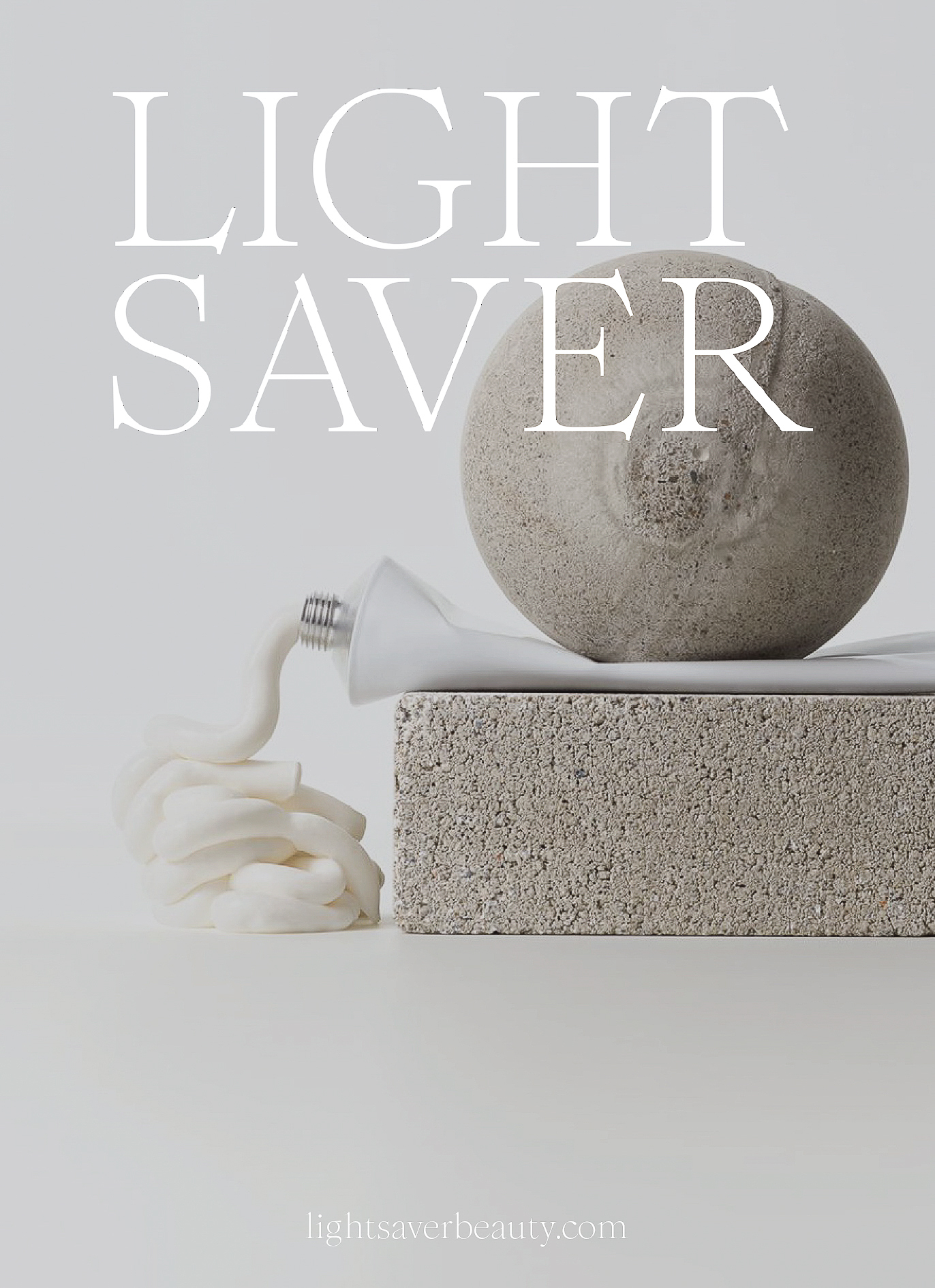 Minimalist beauty product still life: tube of cream next to textured concrete block and sphere on a light grey surface.