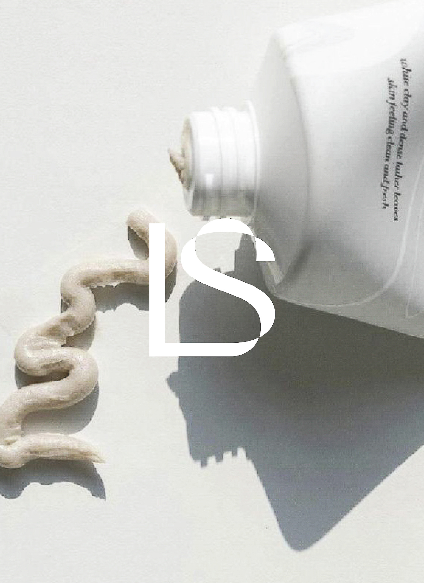 Close-up shot of a white tube with skincare cream coming out of it, swirled on a white surface, ideal for beauty product display.