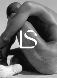 Black and white photo of a curled seated figure with sand on their skin and a white LS monogram logo overlay.