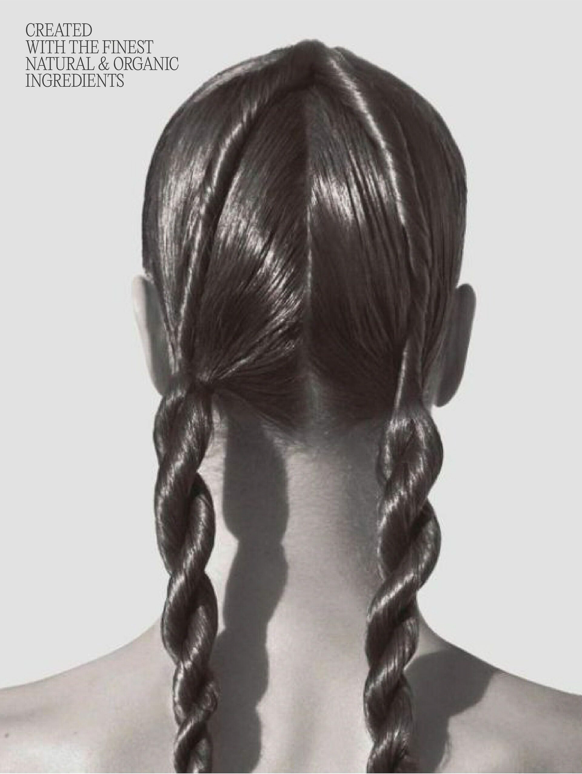 Close-up shot of a woman's head and shoulders, showcasing a hairstyle with twisted braids against a light background. Back view.
