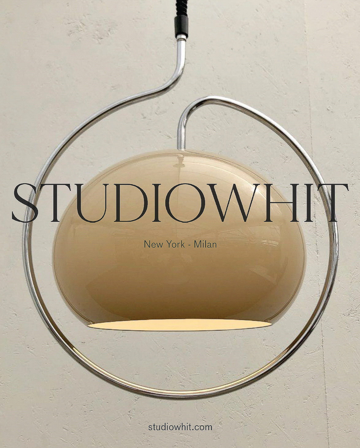 Pendant light fixture with cream-colored shade and a circular chrome support and suspension system in front of an off-white wall.