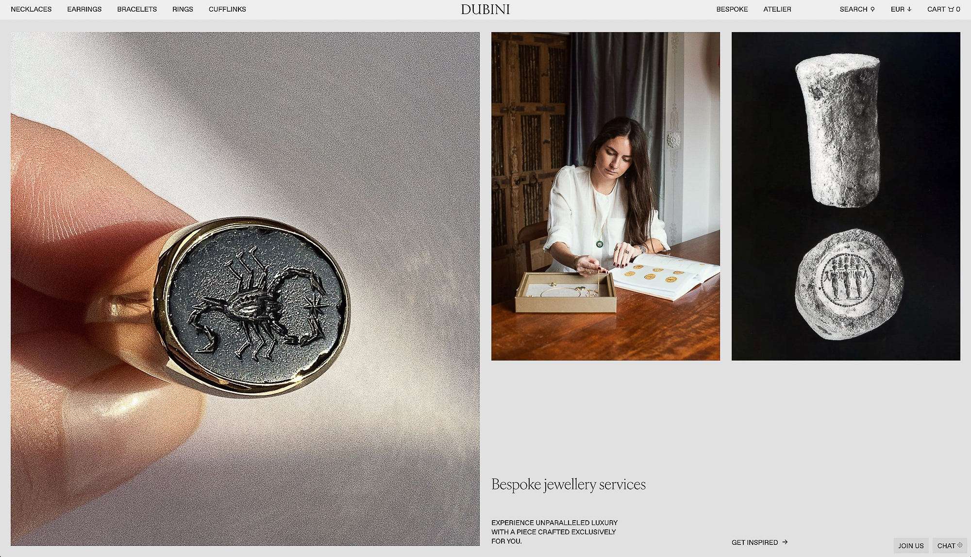 Gold ring with a dark grey stone featuring an engraving of a scorpion. Close-up shot. Woman looks at jewelry catalog in background.