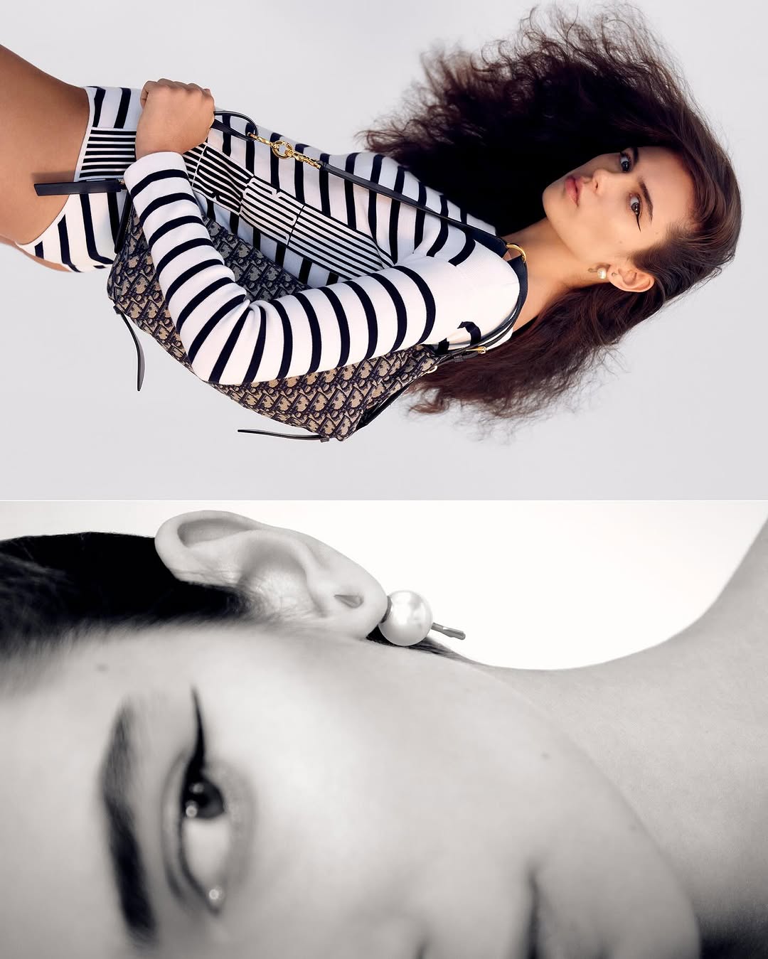 Fashion shot of a young adult woman wearing a striped bodysuit and holding a Christian Dior handbag on a white backdrop.