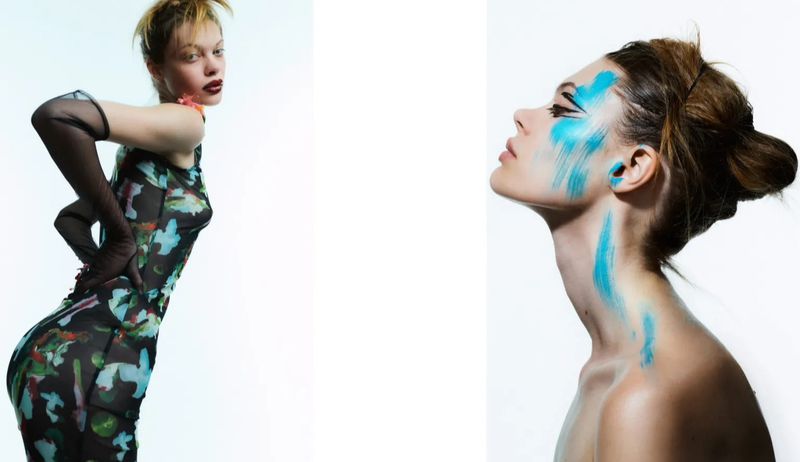 Fashion portrait of a female model with blue makeup, wearing a black printed dress and black gloves against a white backdrop.