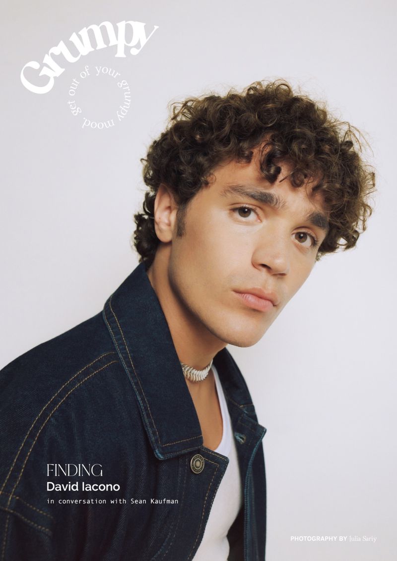Portrait of David Iacono wearing a dark denim jacket and white tank top against a light grey background for 'Grumpy' magazine.