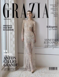 Model wearing a sheer embellished gown standing against an interior wall with classic paneling for Grazia US magazine cover.