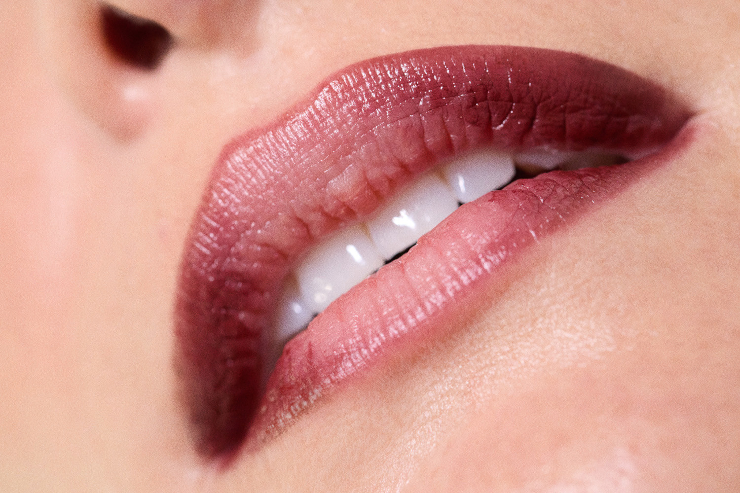 Close-up macro shot of dark plum lipstick on lips with visible white teeth for Heather Kamesky by Love Want