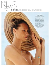 Model wearing a large straw hat and turquoise jewellery against a light sky background for Elle Germany magazine.