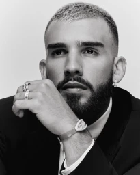 Portrait of Manuel Turizo wearing silver rings, earrings, and a watch for Numero Netherlands editorial photography.