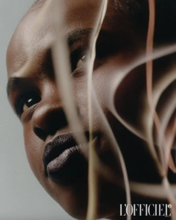 Close-up portrait of a Black adult woman with dark lipstick, captured in a photo studio with soft lighting and artistic lines.