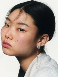 Close-up portrait of model Yoon Young Bae wearing a dangling star-shaped diamond earring against a plain white background.