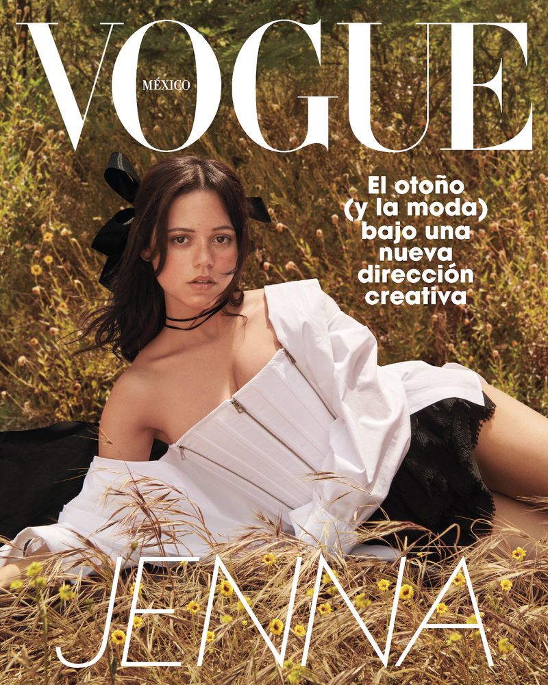 Vogue Mexico cover featuring Jenna Ortega lying in a field of wheat and flowers, wearing an unbuttoned white corset and black ruffled shorts.
