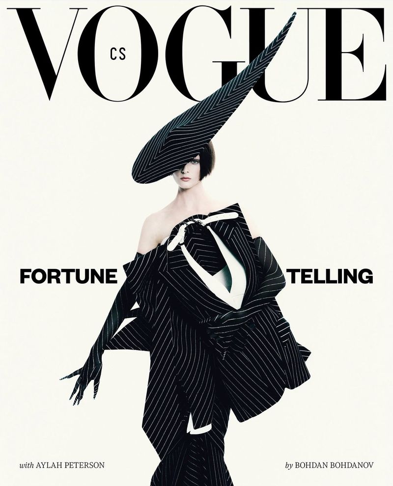 Vogue cover featuring a woman in a striking black and white pinstripe outfit and an oversized hat, set against a clean, bright background.
