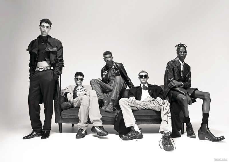 Monochrome fashion editorial featuring a group of five male models posing together on a dark couch against a white background.