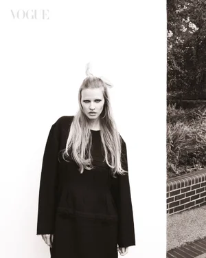 Model Lara Stone wearing a black coat and hair accessory in a monochrome fashion editorial for Vogue Singapore.