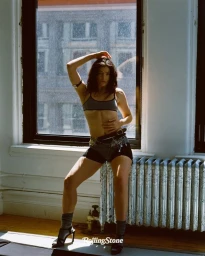 Lorde posing indoors near a window and radiator in a magazine editorial portrait by Theo Wenner