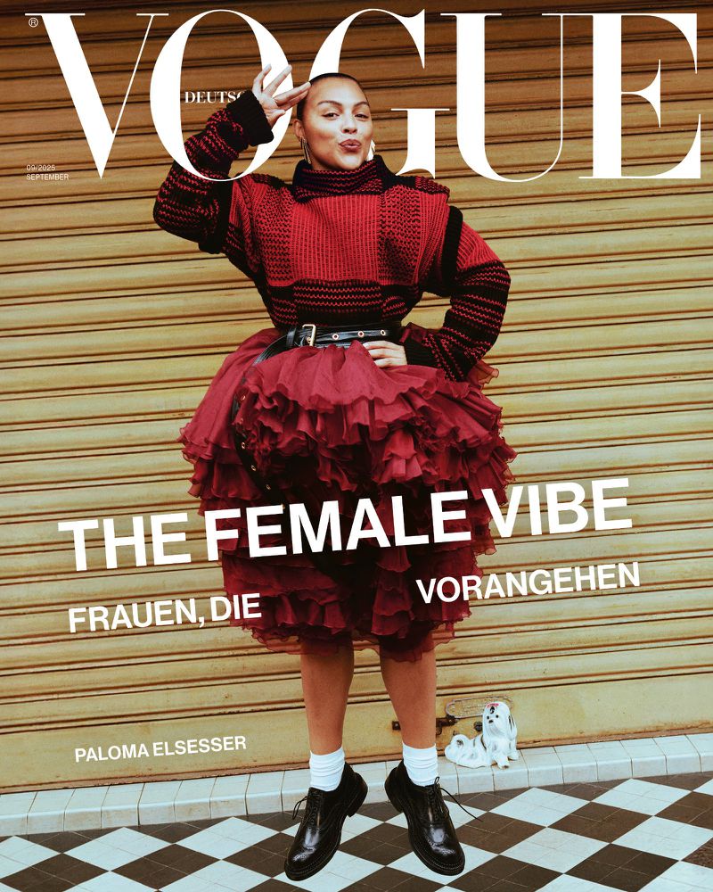 Vogue cover featuring a woman in a red and black outfit, posing on a checkerboard tile floor with a tan roll-down door background.