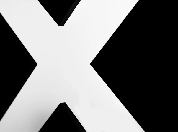 Abstract white 'X' shape against a stark black backdrop, offering a high-contrast visual for graphic design projects and striking imagery.