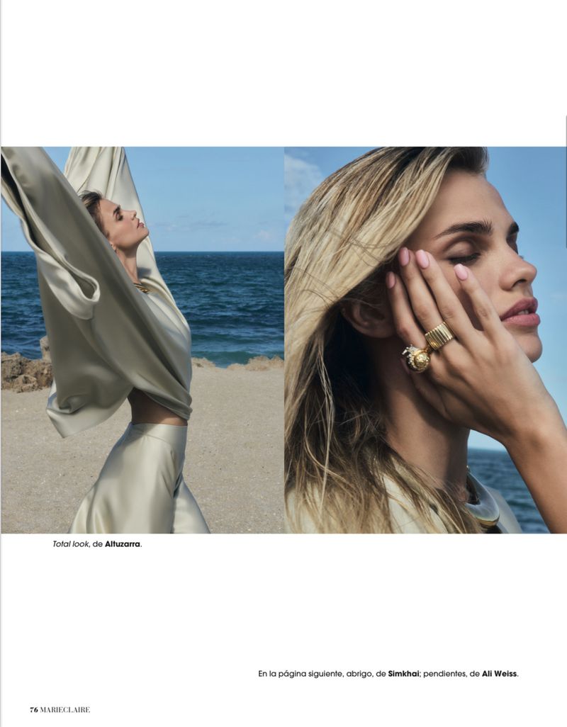 Fashion editorial spread featuring model Dasha Khlystun in a draped cream silk outfit and gold statement ring by the sea.